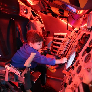 Child Exploring Submarine Simulator at Science Center