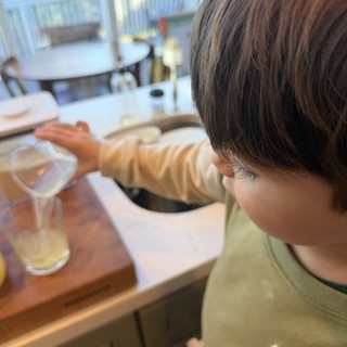 Child Making Fresh Lemonade in Modern Kitchen