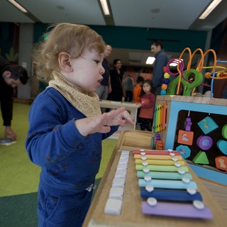Toddler Exploring Colorful Xylophone at Children's Play Center