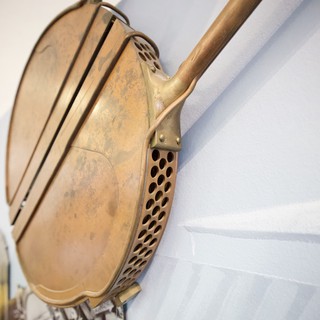 Vintage Brass Bed Warmer Mounted on White Wall