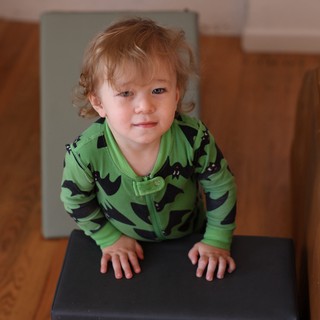Toddler in Green Dinosaur Pajamas at Home