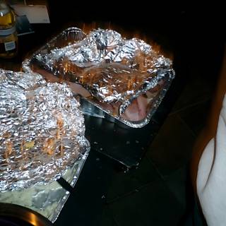 Two Foil Wrapped Trays and a Bottle of Wine