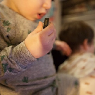Young Child Concentrating on Harmonica Playing at Home