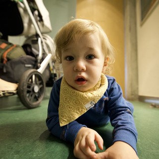 Curious Toddler Crawling on Green Hospital Floor