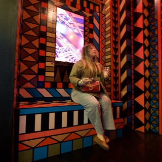 Woman in Vibrant Geometric Installation with Digital Display