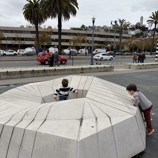 Children Exploring Concrete Amphitheater Steps in Urban Setting