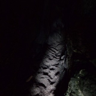 Dark Cave Passage Illuminated by Spotlight