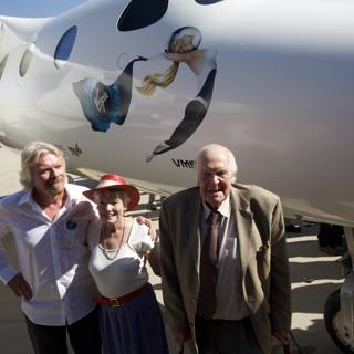 Richard Branson and Companion in Front of Aircraft at Airport