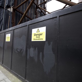 Construction Site Warning Signs on Urban Street Barrier