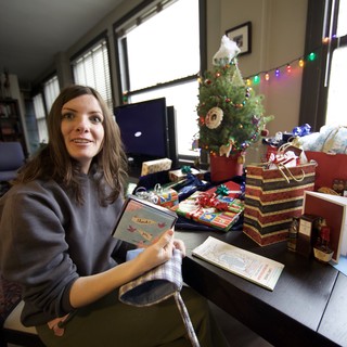 Woman Celebrates Christmas Morning with Gifts and Cards