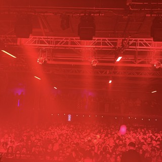 Red-Lit Concert Crowd Under Stage Lighting Rig