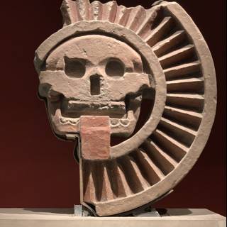 Ancient Stone Sculpture of a Head with Symbolic Wheel Emblem