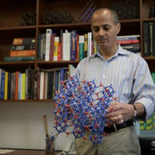 Omar M. Yaghi showcases model of molecule in front of impressive bookshelf