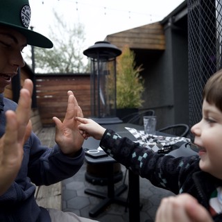 Joyful High Five Between Adult and Children Outdoors