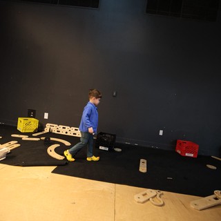 Young Builder on Stage with Wooden Construction Set