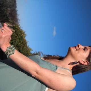 Sunlit Serenity: Woman in Turquoise Jewelry Against Sky