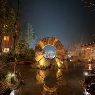 Wooden Portal Sculpture Glowing on a Rainy Night