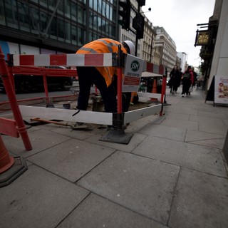 Construction Worker Maintaining Urban Sidewalk in London