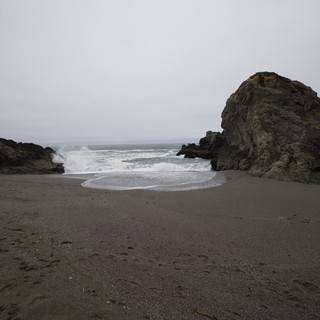 Moody Coastal Cove with Crashing Waves and Sea Stacks