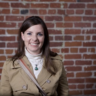 Smiling Woman Portrait Against Rustic Brick Wall