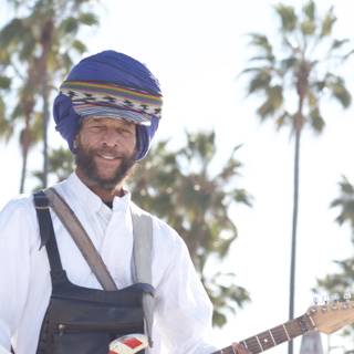 Turbaned Guitarist Smiling Under a Palm Tree
