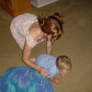 Mother Tenderly Cares for Toddler on Carpet Floor