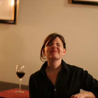 Woman Savoring Red Wine at Restaurant Table