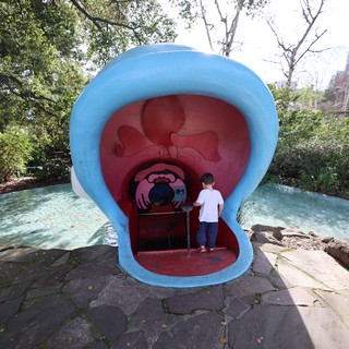 Child Exploring Giant Mouth Sculpture at Fantasyland