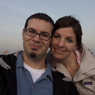 Couple Smiling Together on City Rooftop at Dusk