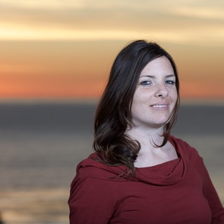 Woman Smiling Serenely at Ocean Sunset