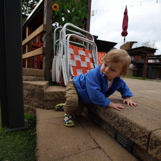Toddler Exploring Outdoor Patio Steps on Cloudy Day