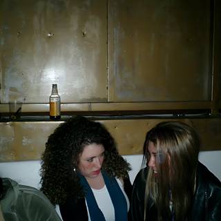 Two Women Enjoying Drinks in Stylish Jackets