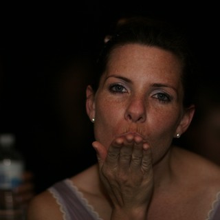 Woman Blowing a Kiss in Dim Party Light