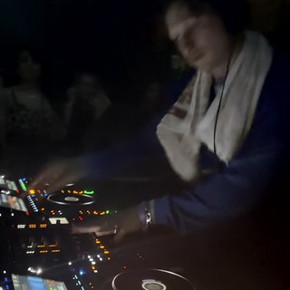 DJ Performing with Professional Pioneer CDJ Equipment at Night
