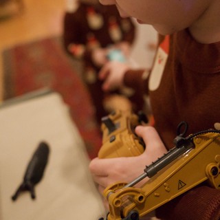 Child Playing with Yellow Construction Toy Crane at Christmas