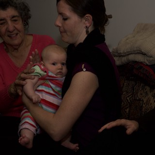 Three Generations Share a Tender Moment with Newborn