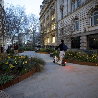Electric Scooter Rider in London Garden Square at Dusk