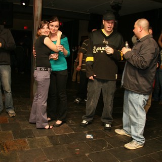 Friends Embrace at a Lively Holiday Bar Gathering