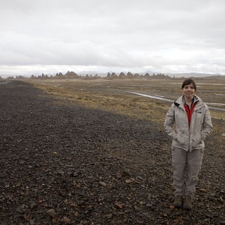 Woman Standing Among Ancient Tufa Spires in Desert