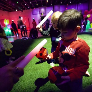Children Playing with Glow Sticks at Baby Rave Event