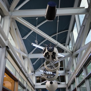 Vintage Space Telescope Suspended in Modern Observatory Atrium