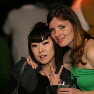 Two Friends Pose Together at a Nightclub Event