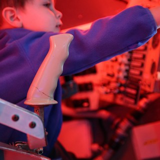 Child Interacting with Robotic Arm at Science Center