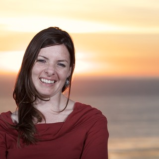 Radiant Woman Smiling at Sunset by the Sea
