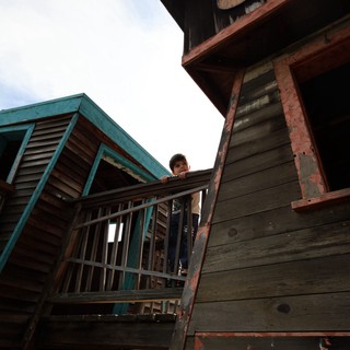 Person on Weathered Balcony of Old Western Building