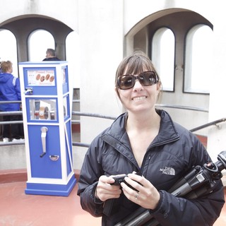 Photographer Smiling at Pressed Penny Souvenir Machine
