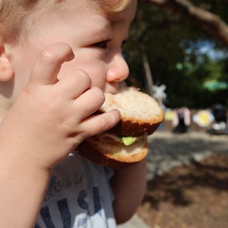 Young Child Enjoying a Burger Outdoors