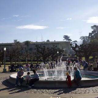 Families Gathering Around Fountain on Sunny Day