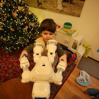 Child Playing with White Robot Toy on Christmas Morning