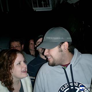 Couple in Baseball Caps Smiling at Each Other